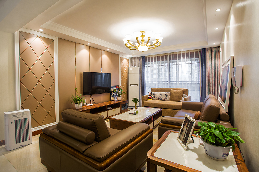 客廳整體風(fēng)格采用硬包和素色墻紙的搭配，地面采用大理石的拼花方式，在顏色上做了統(tǒng)一，配上精致美式燈和深淺相間窗簾裝飾，配以重色沙發(fā)，使整個客廳華而不炫，彰顯業(yè)主的獨特品味。
