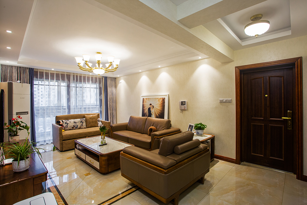 客廳的沙發(fā)背景采用了素色墻紙，彰顯結(jié)婚照的獨特，吊頂采用簡單修飾，空間全部留給層高，得以視覺增加。
