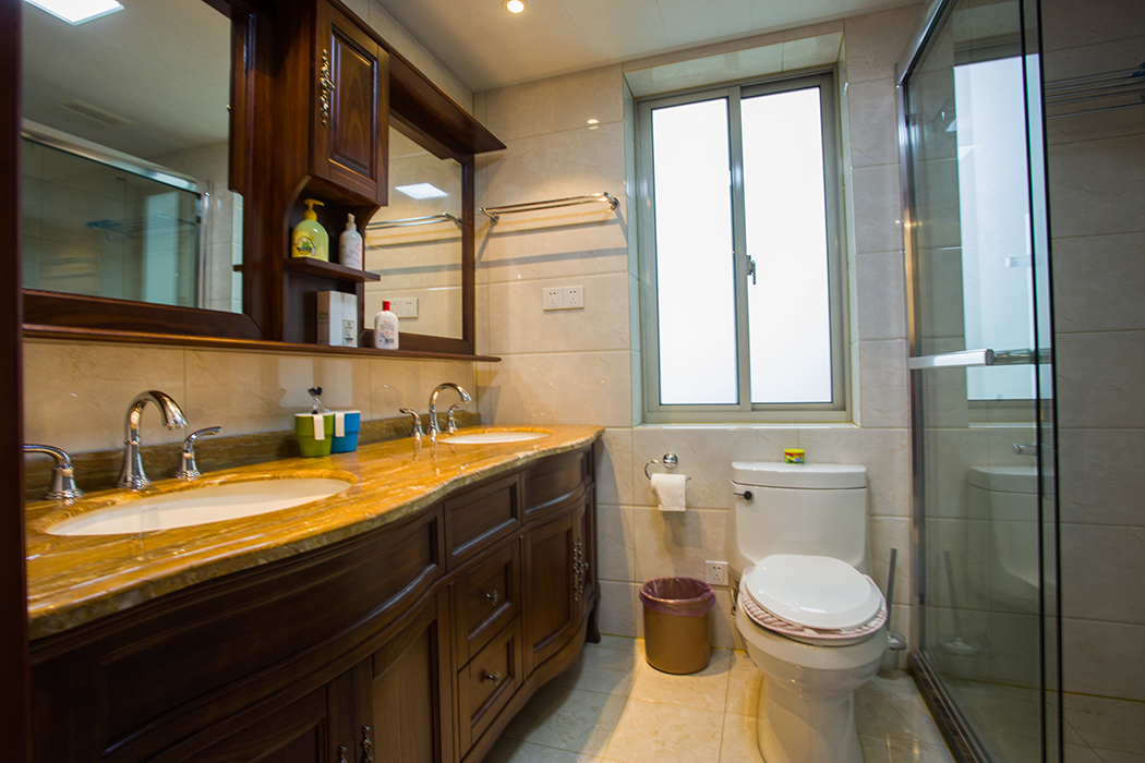 衛(wèi)生間采用雙臺盆柜，深色柜體加以黃色大理石臺面，充分體現(xiàn)客戶金碧奢華的生活，既時尚又大氣。
