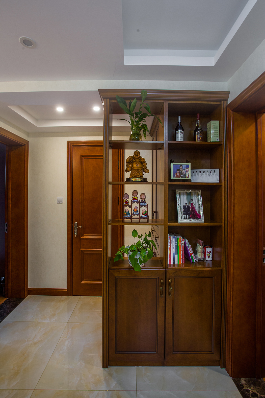 玄關(guān)處采用整體定制玄關(guān)，既美觀而又通透，即避開衛(wèi)生間的門和入戶門的沖突，又起到點綴生活的作用，舊時的照片，喚起業(yè)主家庭生活的美滿。