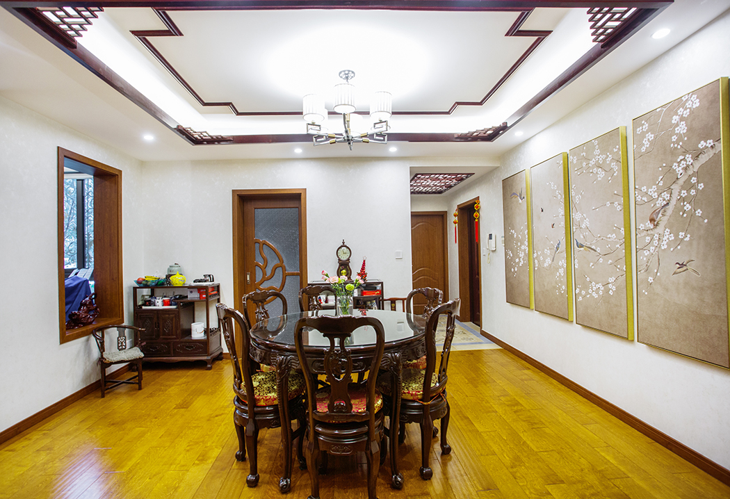 中國傳統觀念講究平和中正，因此整體吊頂考慮就是簡單大氣的方形邊吊，為了突出中國風加入了中式角花線條作為裝飾，展現出中式風格沉穩厚實的氣質。左邊窗戶通向陽臺，簡單做個窗框而不加窗戶讓整個中國風體現的更加生動，從正面看過去也正好是一片風景裝飾畫，與對面掛的這四副花鳥圖相對稱。
