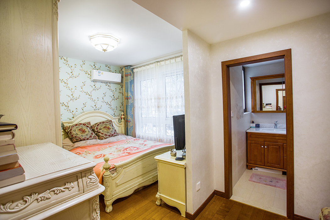 客廳吊頂與餐廳吊頂相統一，但只有這些也是不夠的，將中式元素的花鳥壁紙設計在電視背景墻之中，看起來就像兩扇中式屏風，加入木線條更顯沉穩內斂。
