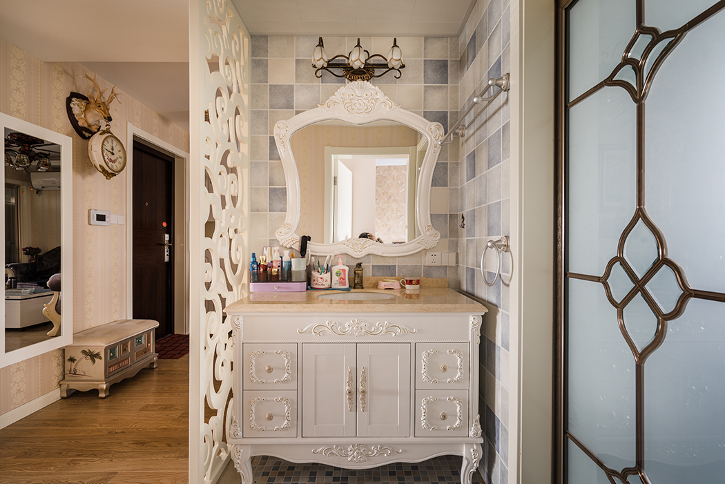 進(jìn)門(mén)的干區(qū)處理，配上歐式的漏空花格隔斷，把原本不大的衛(wèi)生間拓展的實(shí)用而且美觀，歐式臺(tái)盆柜和古典的鏡前燈，更突顯出主人的品味。
