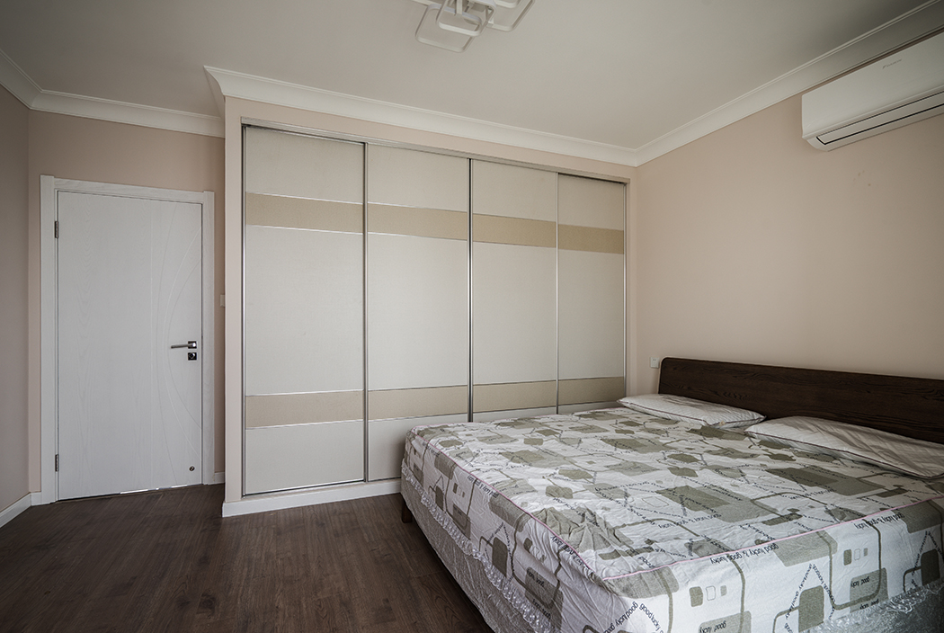 房間沒有更多繁復的裝飾，墻面涂料，頂面石膏線裝飾，不多摻雜一絲，質感非常強的古色地板，本身紋路就非常漂亮，再搭上簡單的梳妝柜凸顯整體風格。
