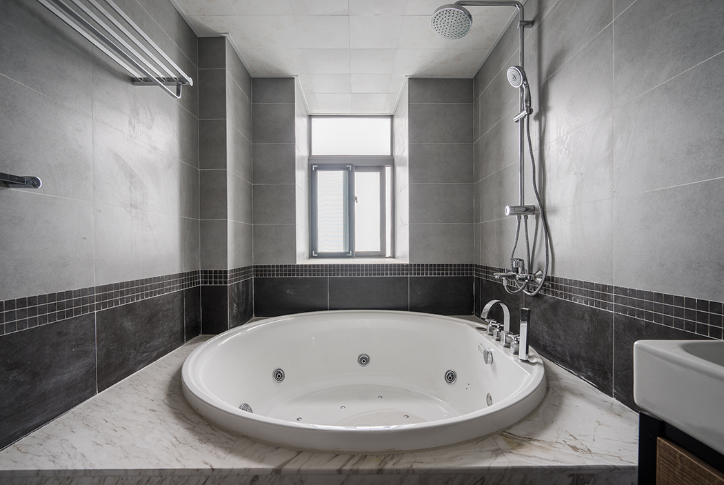 衛生間主人需求的大型沖浪浴缸，爵士白的大理石，白色的潔具，和黑灰的墻地磚使空間獨顯大氣，更滿足了功能需求。
