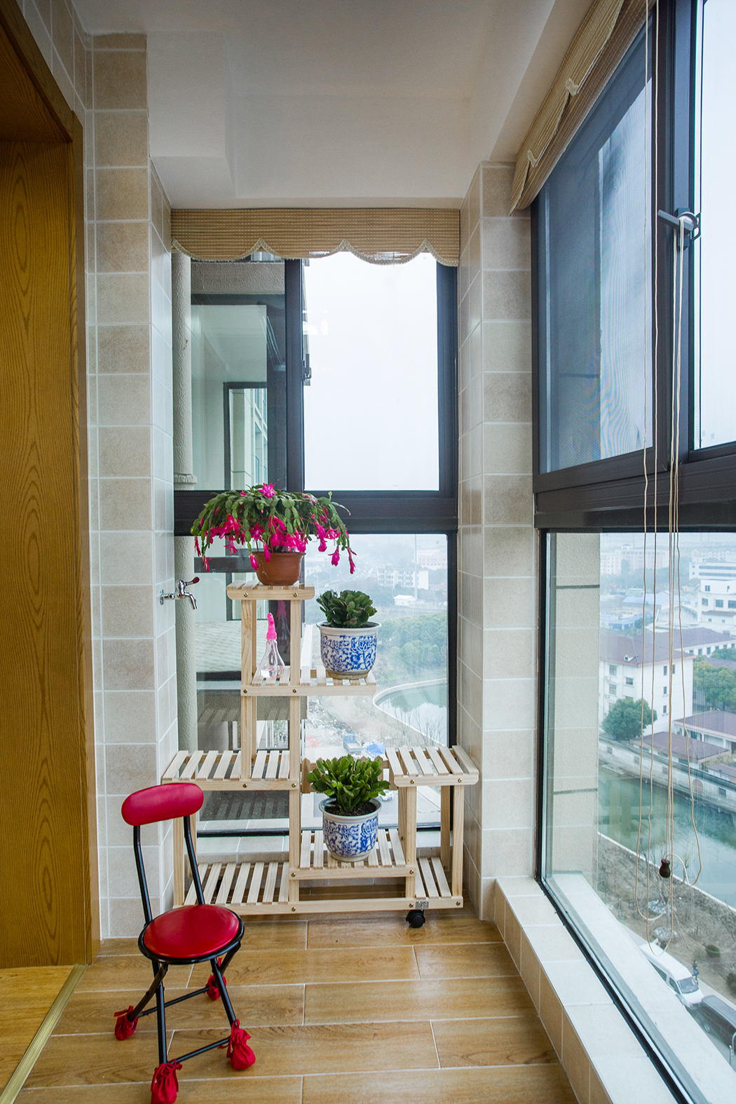 陽臺的地磚使用的是仿地板地磚，跟客廳的地板顏色接近，這樣不僅有整體性，也會讓整個空間加長，還有業主養了好幾年的蟹爪蘭，，整個陽臺都賦予了生機。
