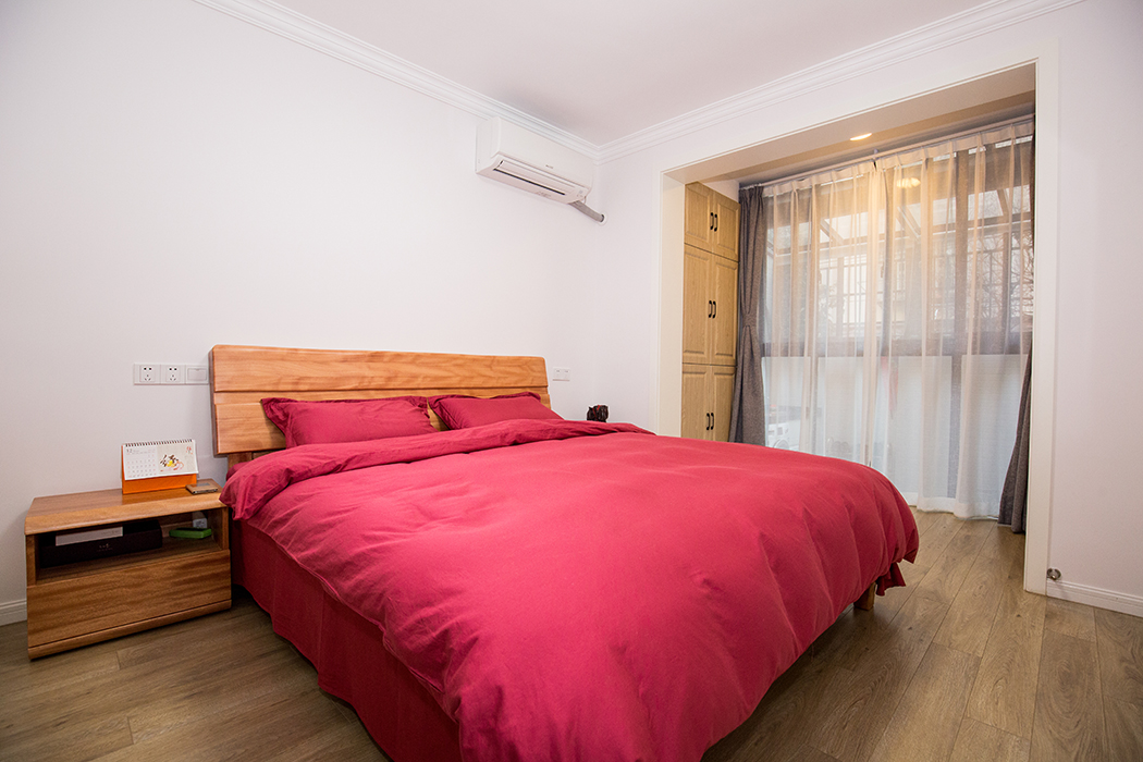 房間以原木色為主，落地玻璃可以讓陽光全曬進來，原本陽臺區(qū)域擴到房間，還增加了兩面儲物柜，房間以溫暖舒適為主。
