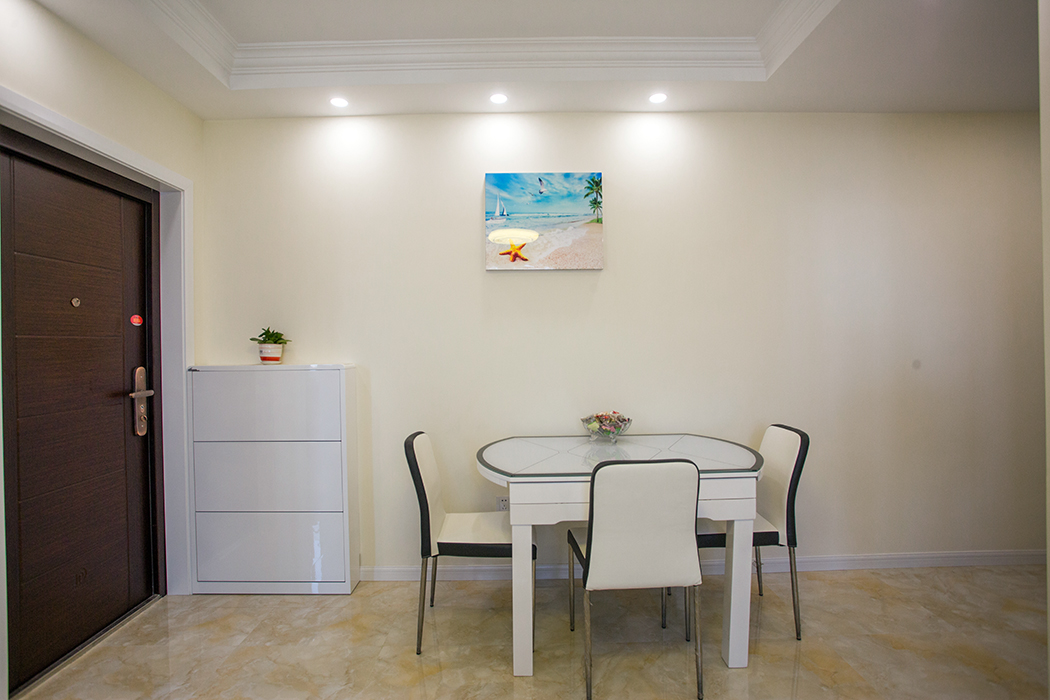 餐廳的背景采用了小幅掛畫做處理，顯得精致小巧。配上白色鞋柜以及簡潔餐桌顯得敞亮秀氣。過道連接餐廳，遙相輝映，通透而又悠長。
