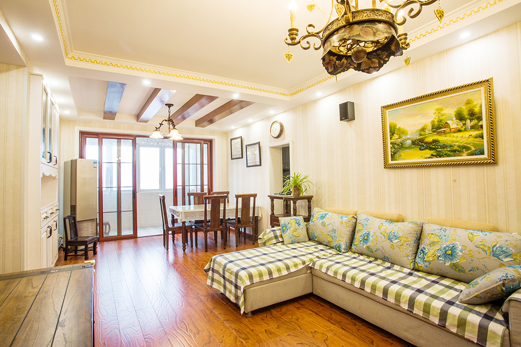 客廳為了襯托美式田園式的深色家具，客廳采用深色的仿古地板，使得整體協調，也更凸顯了家具的質感，品質生活油然而生。美式田園家具低調而奢華，充分體現了業主的，低調而內斂的做人風格。
