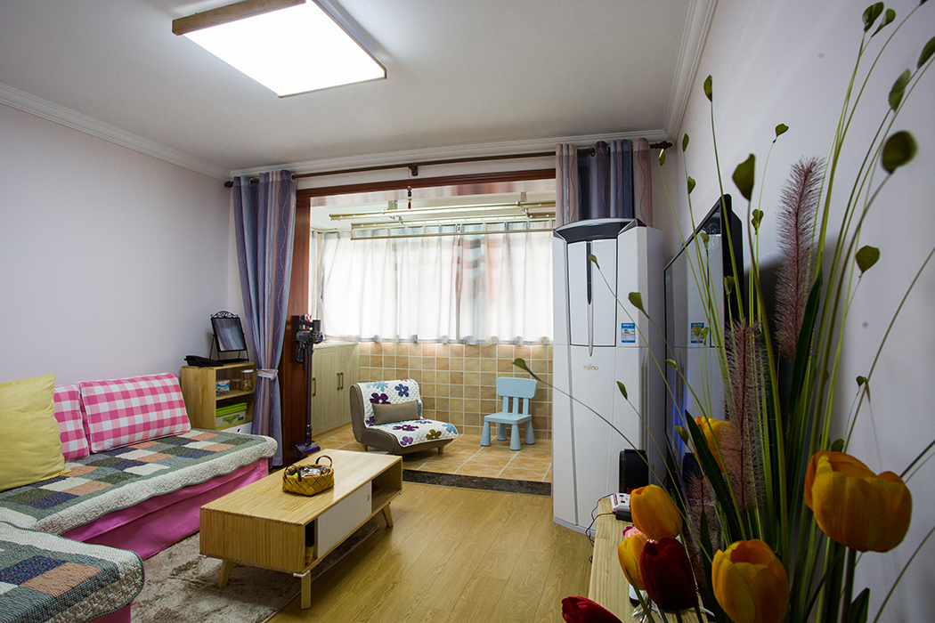 空間從色彩到材質到家具的選擇，盡顯簡約與舒適氣息。整個空間以亮色為主色調，現代的硬朗線條和咖北歐家具的組合，有種現代線條感?？蛷d亮色絨面沙發與粉紅靠墊、原木邊柜組合增添幾分歡快與質感。
