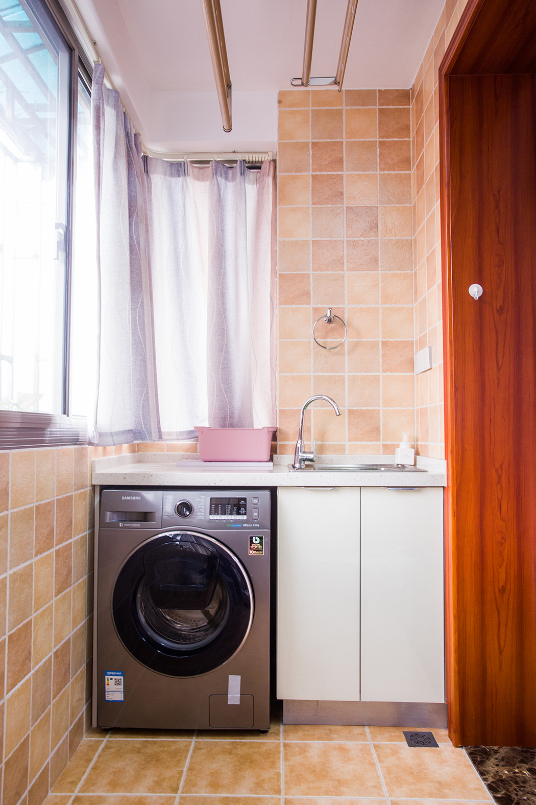 空間從色彩到材質到家具的選擇，盡顯簡約與舒適氣息。整個空間以亮色為主色調，現代的硬朗線條和咖北歐家具的組合，有種現代線條感。客廳亮色絨面沙發與粉紅靠墊、原木邊柜組合增添幾分歡快與質感。
