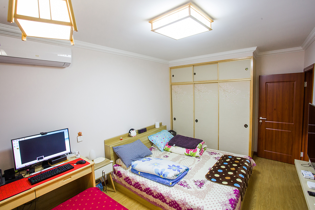 空間從色彩到材質到家具的選擇，盡顯簡約與舒適氣息。整個空間以亮色為主色調，現代的硬朗線條和咖北歐家具的組合，有種現代線條感。客廳亮色絨面沙發與粉紅靠墊、原木邊柜組合增添幾分歡快與質感。