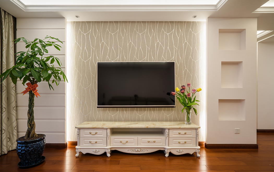 客廳電視背景采用石膏板造型結合藝術墻紙相搭配，簡潔大方。可能是女主人還沒選好更喜愛的飾品，壁龕若再做一些裝飾，那將更加完美。
