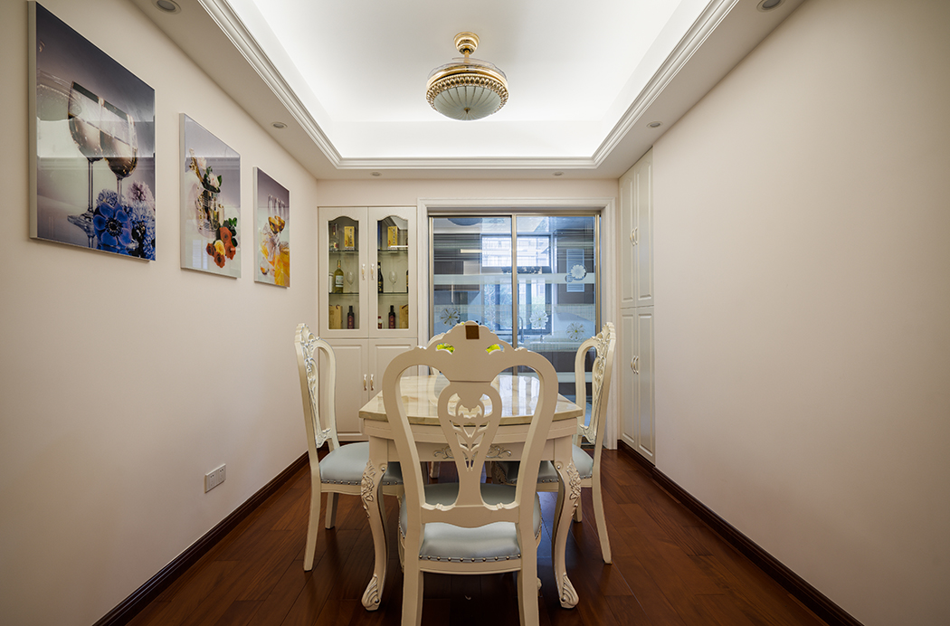 餐廳和廚房用透明玻璃隔斷使空間，更加通透方便。旁邊增設裝飾酒柜實用美麗，女主人精心挑選的幾幅裝飾畫讓整個餐廳空間更加舒適。
