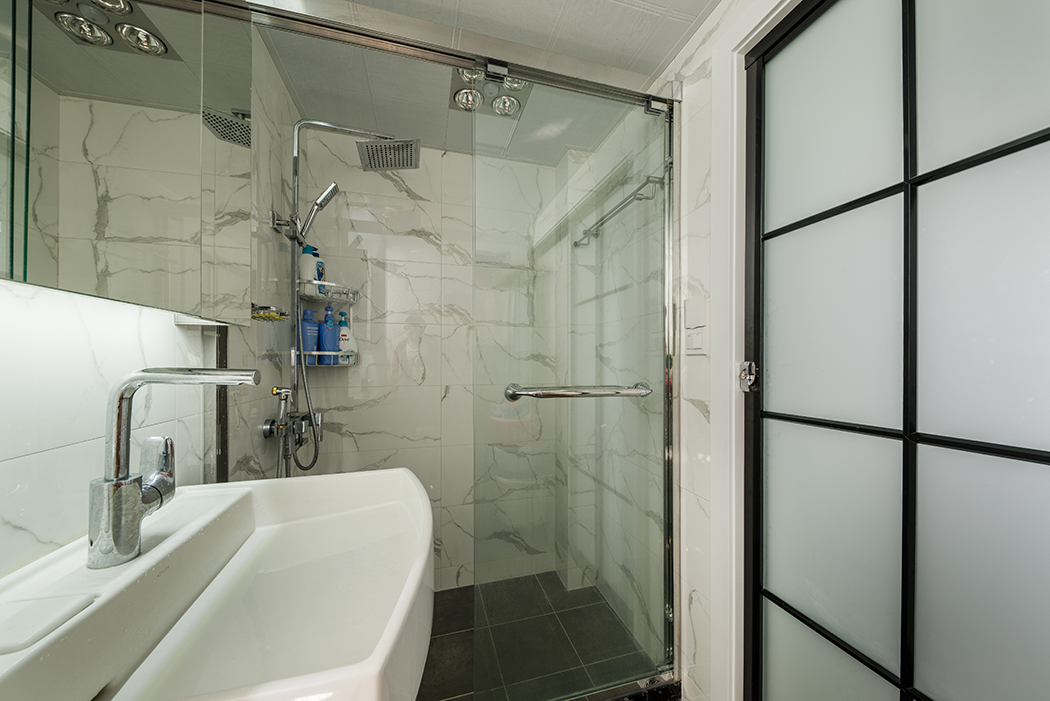 衛(wèi)生間采用仿大理石的瓷磚，看上去簡單而又不失奢華，新浪莎的玻璃隔斷，科勒的臺盆，馬桶，加上谷倉門，整體搭配大氣奢華。充分體驗業(yè)主的品味。簡單，大氣，黑白加之大理石般的瓷磚透露出業(yè)主是一個愛生活，有氣質(zhì)的人。
