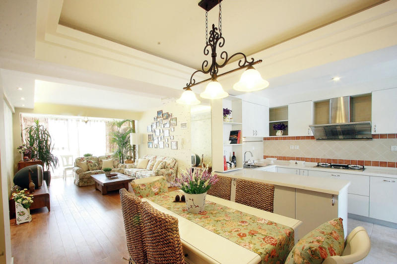 一走進(jìn)室內(nèi)你就會(huì)感到一股清新、自然、悠閑的田園風(fēng)迎面而來(lái)。客廳小碎花沙發(fā)搭配背后的照片墻、綠植、軟裝配飾，讓客廳給人閑適的感覺(jué)，良好的采光和通風(fēng)效果、餐廳、廚房開(kāi)放式的設(shè)計(jì)手法避免空間狹小、壓抑的感覺(jué)，讓業(yè)主的生活環(huán)境更加的愜意。