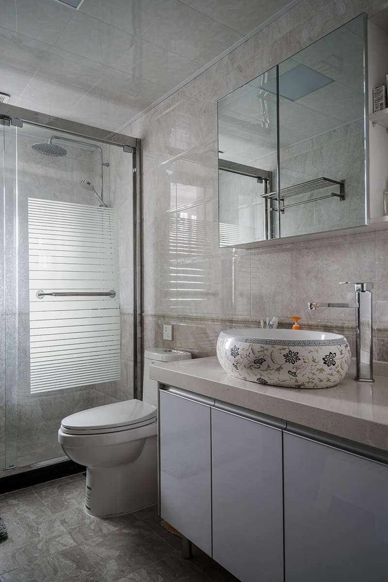 衛(wèi)生間的采光明亮，空間也適中，瓷磚用了腰帶區(qū)分了兩種顏色，簡約但是又不簡單，定制的臺盆柜和鏡柜都是按照客戶的需要量身定制，所使用的板材又是防水耐用的。
