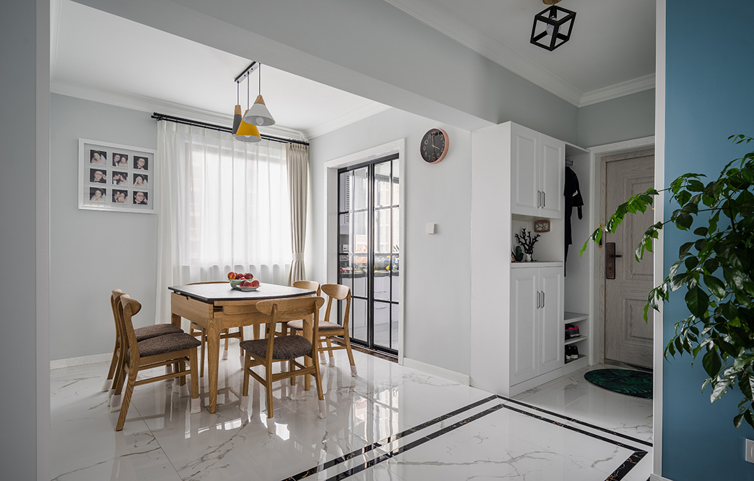 在餐廳的設(shè)計上，我們延續(xù)了客廳的灰調(diào)，明黃色餐廳燈給整個空間多了一絲明快，原木色的餐椅以及深色坐墊現(xiàn)代感分明，淺色窗簾元素中削減了空間的硬度。黑色格子玻璃門與餐廳風(fēng)格保持協(xié)調(diào)統(tǒng)一。
