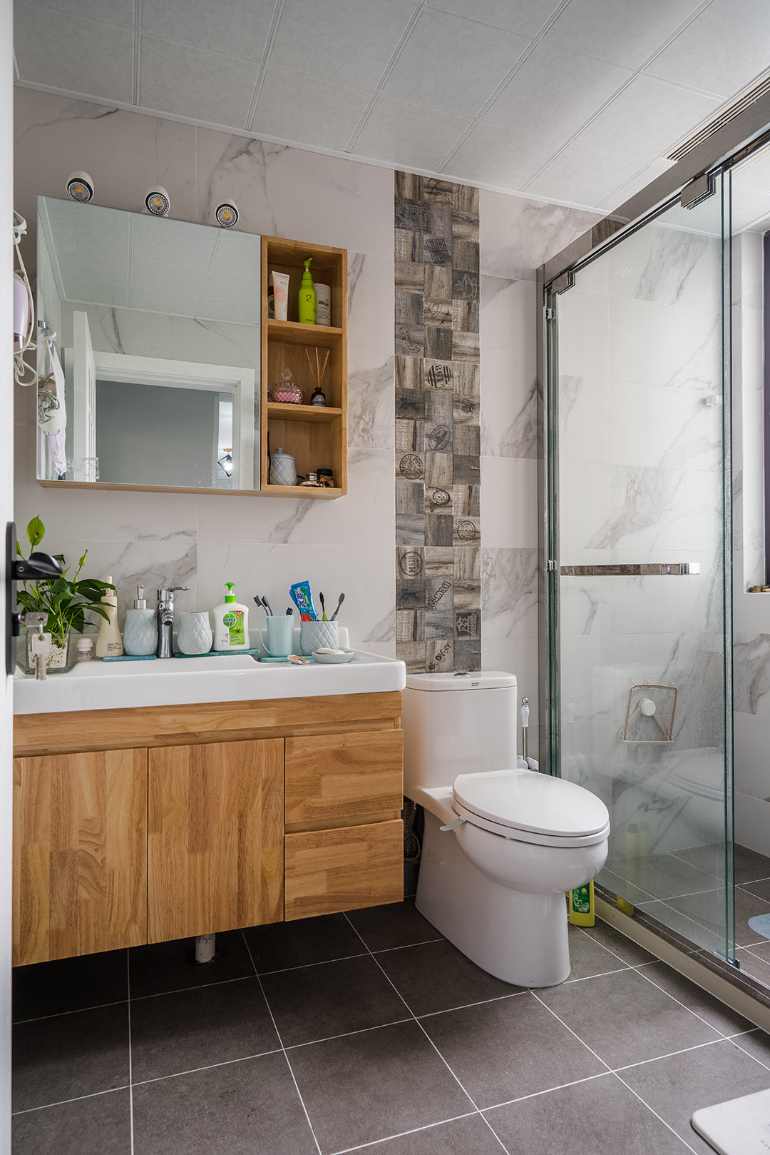 衛(wèi)生間灰色地磚配上白色墻磚層次分明，馬桶背后的腰帶設(shè)計點亮了整個空間。
