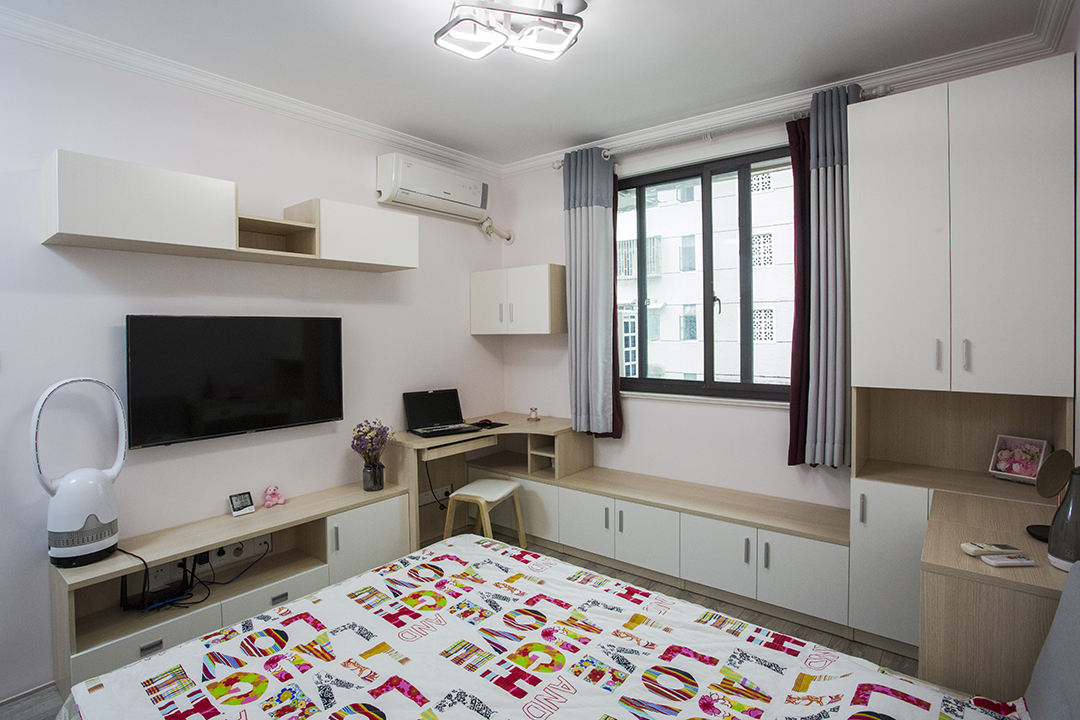 將電視柜與書桌以及窗邊休息座連為一體，在相對有限的空間內盡可能的豐富功能需求，以淺粉色作為空間的基調，輔以淺木紋、中性灰色適當點綴修飾，營造溫馨氛圍。
