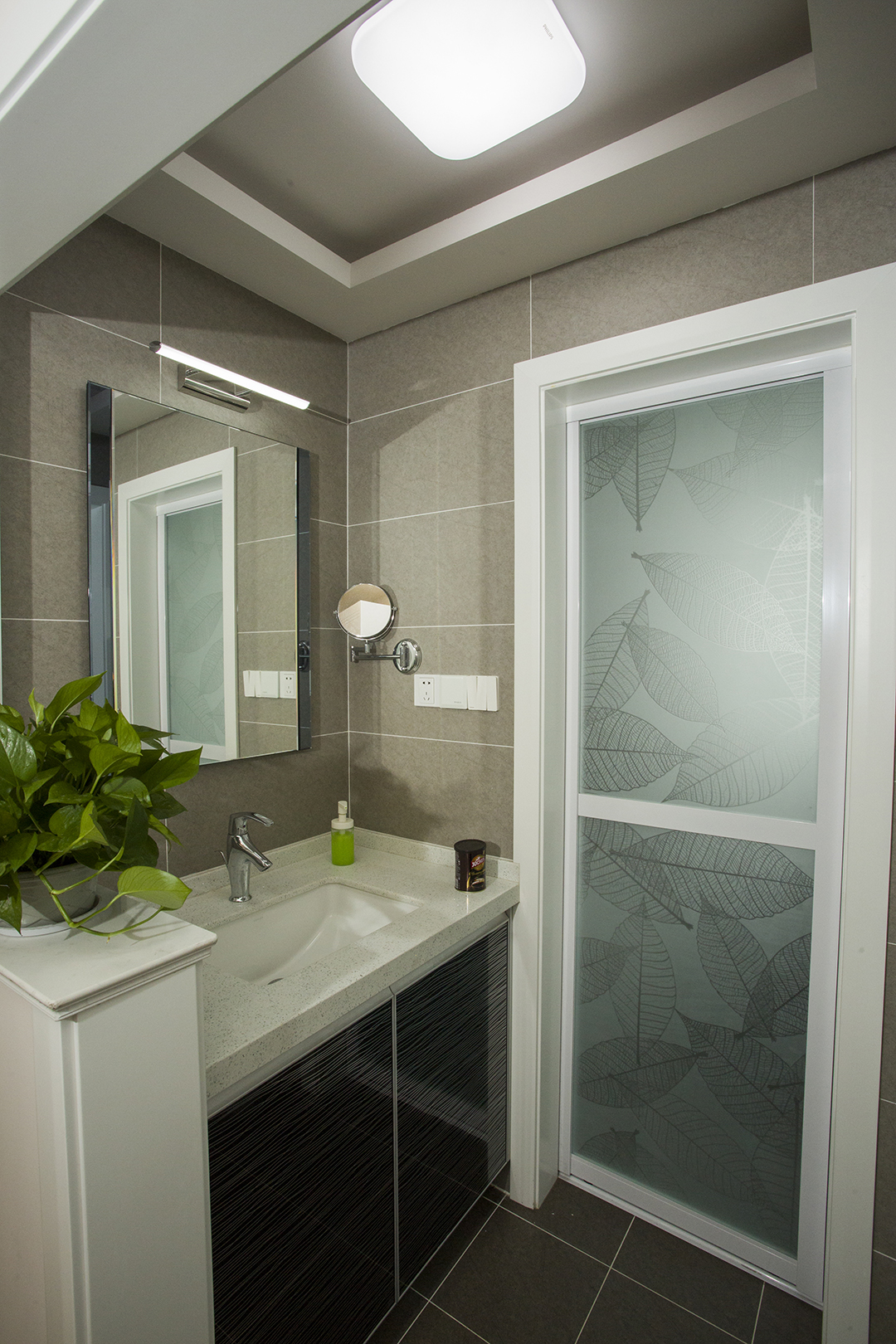 衛生間采用灰色瓷磚，白色臺面加以黑色柜門，充分體現客戶對于后現代風格的要求，隨時感受自己新的生活，既時尚又大氣。
