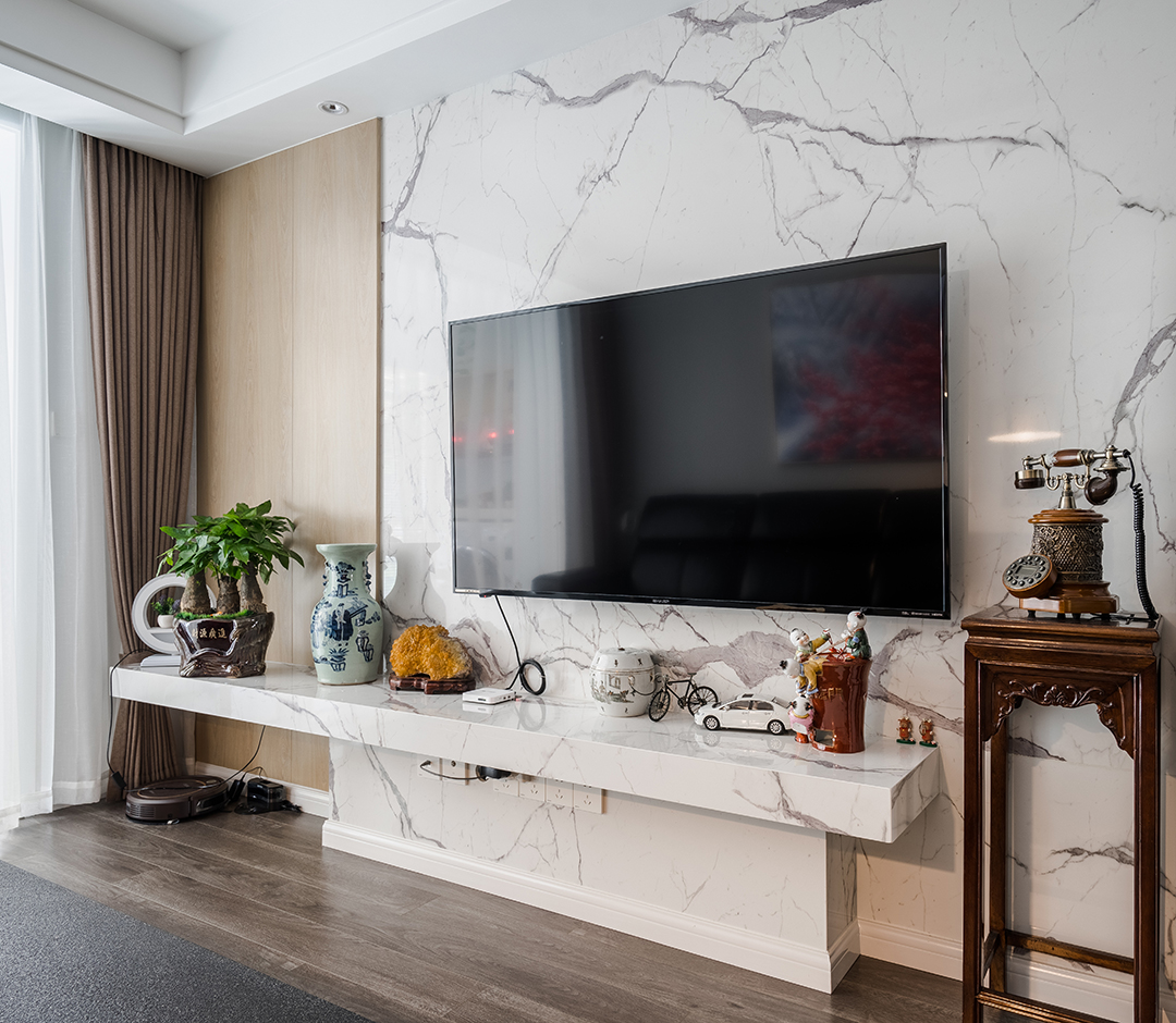 白是淺唱低吟，黑是濃情訴說(shuō)，原木與石材的完美搭配，剛?cè)岵?jì)，共同筑一方引人入勝心馳蕩漾的天地。色彩的魔力在于它所傳達(dá)的溫暖和釋放的感情是易被察覺(jué)與感染的，以黑白灰為主色調(diào)的客廳，使整體空間具有一種隱晦的沉穩(wěn)和出其不意的恬淡美感。
