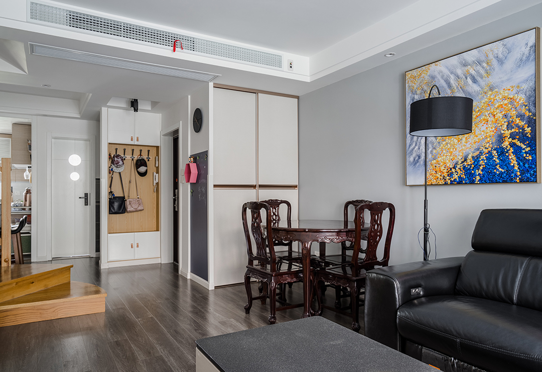 白是淺唱低吟，黑是濃情訴說(shuō)，原木與石材的完美搭配，剛?cè)岵?jì)，共同筑一方引人入勝心馳蕩漾的天地。色彩的魔力在于它所傳達(dá)的溫暖和釋放的感情是易被察覺(jué)與感染的，以黑白灰為主色調(diào)的客廳，使整體空間具有一種隱晦的沉穩(wěn)和出其不意的恬淡美感。
