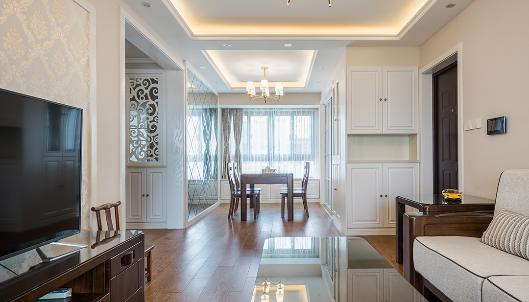 客廳實木地板和實木家具讓一切回到最初的純粹，米黃色的墻面搭以同色系的沙發(fā)，稍加點綴的窗簾，整個空間通暢自然。
