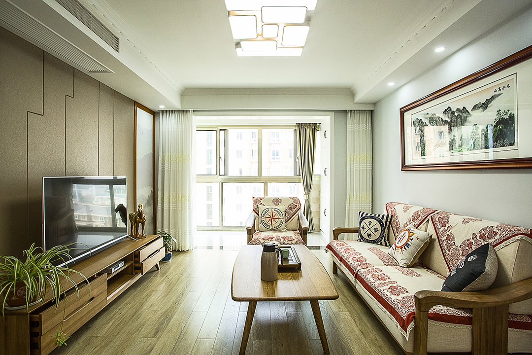 客廳去掉了復雜的中式風格裝修背景墻，采用硬包布與墻紙的形式。增加了空間的明亮度，給人一種清新大氣的感覺，同時米色的沙發配上淺棕色的軟包更是加強了空間視覺感。讓中式風格裝修的空間不再單調反而充滿了趣味性，形成了簡約與復雜，現代與傳統的完美結合。
