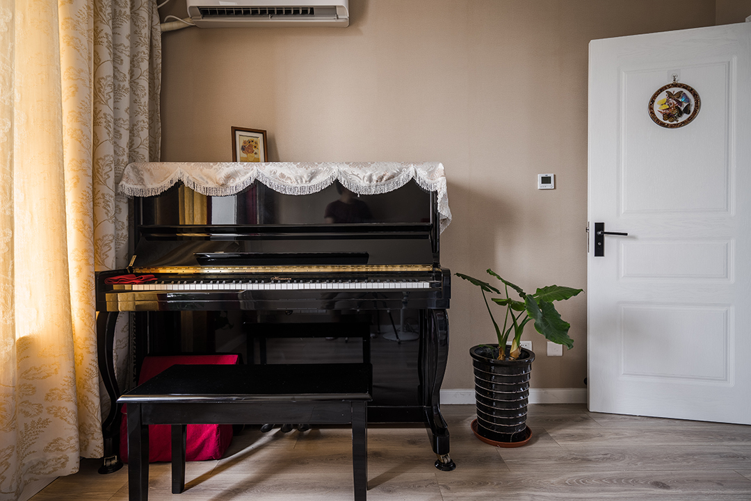 客廳的墻面采用了深綠色壁紙，給墻面增加了不一樣的色彩
