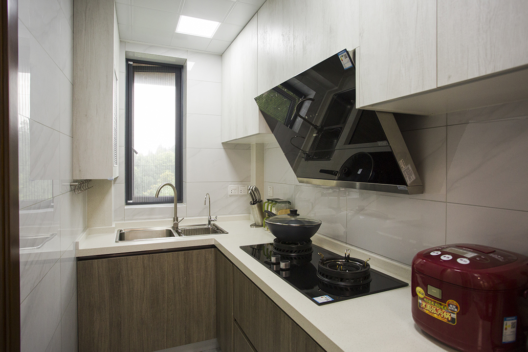 廚房間爵士白的墻磚，作為背景色簡單卻不失大氣，櫥柜上淺下深，更給人以踏實輕快的感覺，胡桃木色配上白色木紋的櫥柜，沒有歐式的奢華，卻多了現代的簡約和美式的恬淡。
