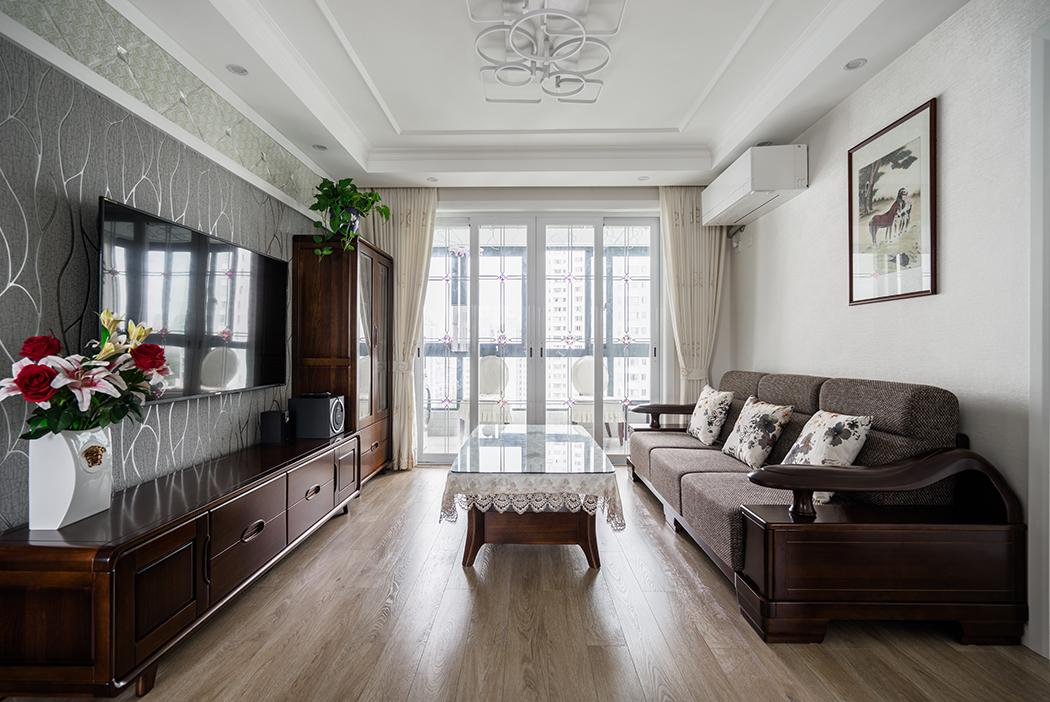 20180917-1025-客廳簡潔的線條與米色的墻面，地面凝結(jié)成暖調(diào)，營造了一片溫馨；實木家具與墻面以強烈的色彩，陳設(shè)出家的自在和品質(zhì)。
