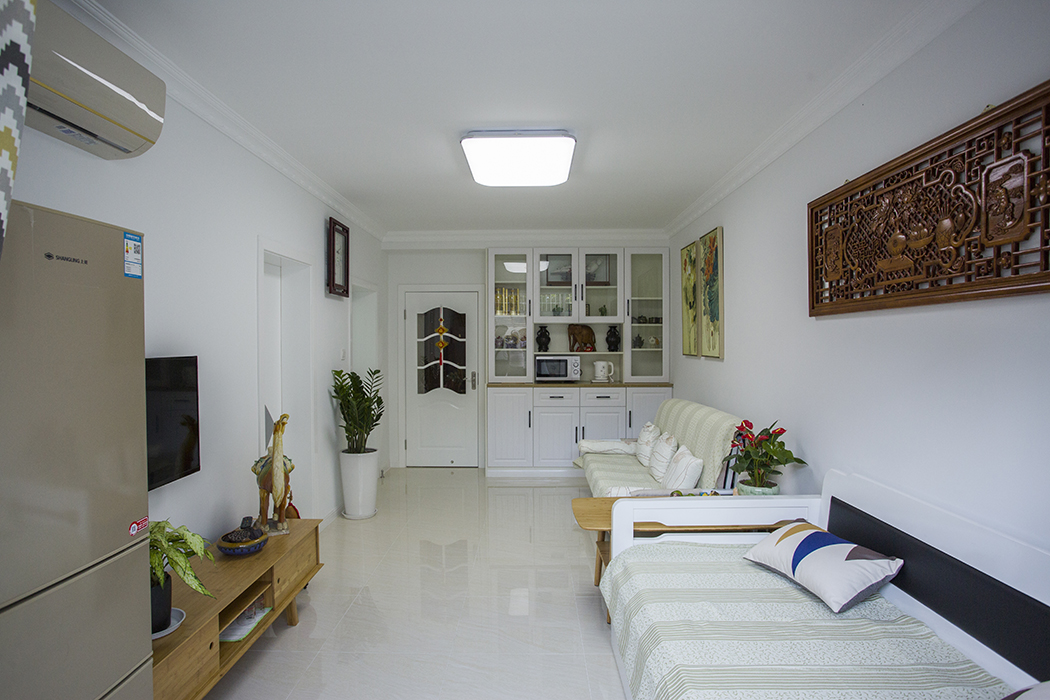 客廳整體風格采用中式木雕、中式畫作為點綴，在現代風格里做了一個美好的點綴，在顏色上做了統一，配上精致的玻璃燈的裝飾及綠色植物的配飾，讓空間更具有生命活力。
