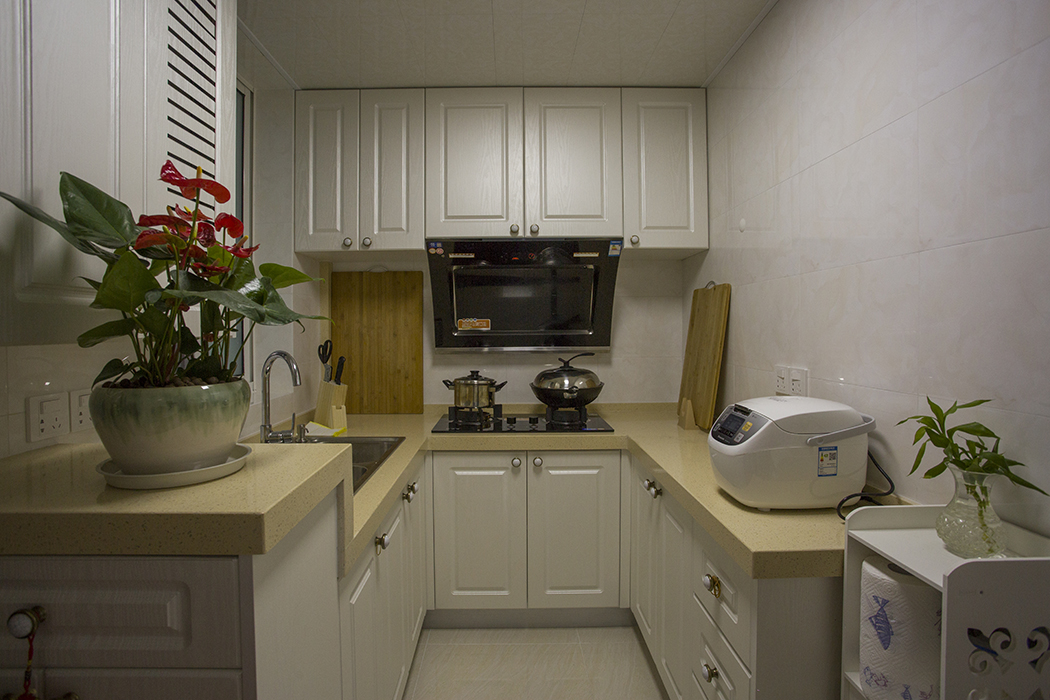  集功能為一體的廚房更是實用之作，綠植下方是進戶鞋柜，上口室臺面，讓廚房的更具有功能性，簡潔的柜門，高低錯落及顏色突出的臺面，讓人眼前一亮。
