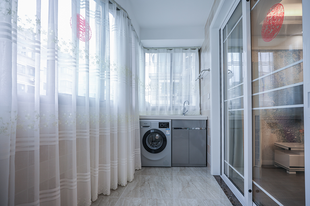 陽臺暗藏式窗簾盒完美的體現了房屋結構的曲線美，暗藏式儲物柜加上整體洗衣柜作為功能陽臺，滿足了業主日常的洗衣儲物功能!
