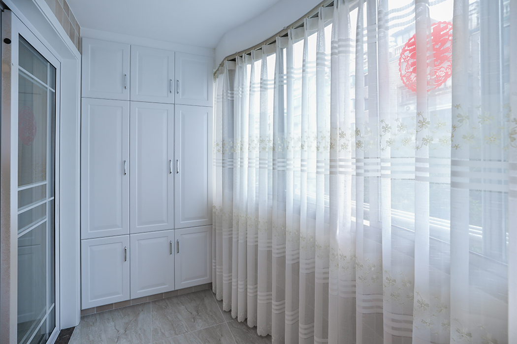 陽臺暗藏式窗簾盒完美的體現了房屋結構的曲線美，暗藏式儲物柜加上整體洗衣柜作為功能陽臺，滿足了業主日常的洗衣儲物功能!
