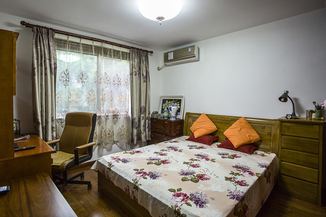 主臥室造型簡單，實木大床，簡潔吊燈以及空間利用性的儲物空間和簡約的色彩感更容易平復好心情，讓人安然入睡。無論從顏色的搭配到家具擺設都給人以安靜、舒適的感受。
