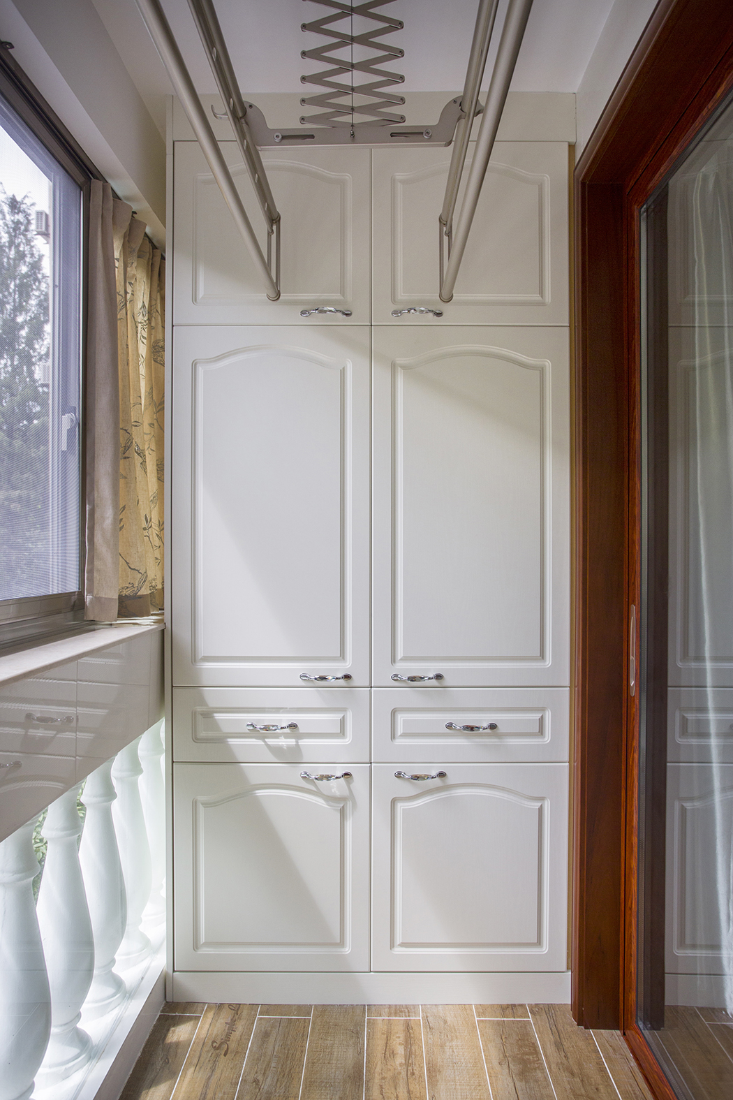 小小的陽臺設計別出心裁。首先設計上，上面晾曬衣服，旁邊有以收納為主的櫥柜，有著簡化的線條，自然的材質。