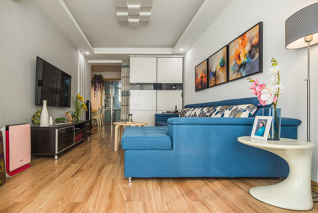 客廳空間內(nèi)以原木色的地板和米白色的墻紙主色調(diào)，色明快的軟裝及家具設(shè)定，做了有趣的色彩撞擊，生動玩味，白色的定制柜及木飾面豐富了整體材質(zhì)，在輕奢主義的格調(diào)里融入一些原生態(tài)的溫馨舒適且隨意自然的風(fēng)情。
