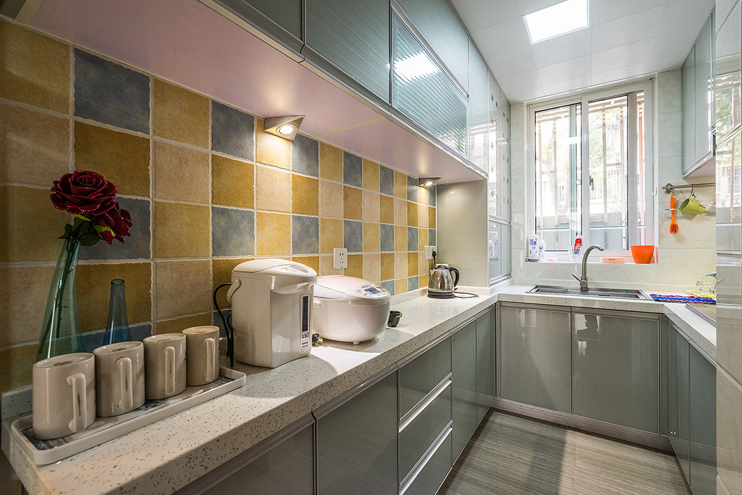 不大的廚房，麻雀雖小，五臟俱全。廚房的櫥柜選用了非常現(xiàn)代的材質(zhì)，豐富的儲物空間將雜物收納妥當(dāng)，在灰色的背景色下，顯得更加潔凈清爽。
