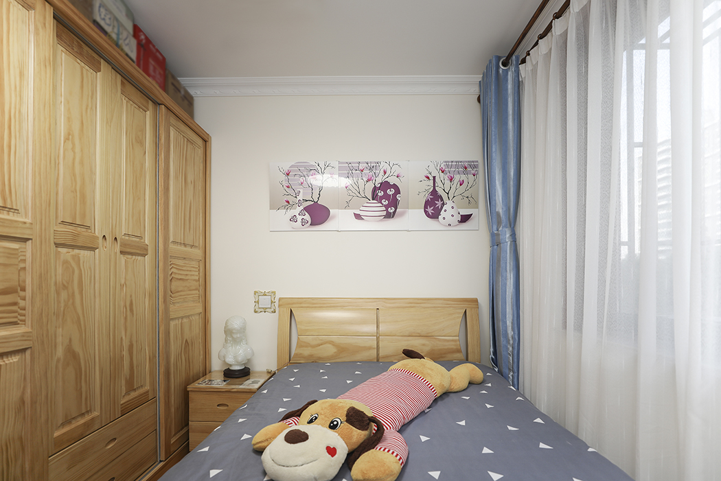 次臥的墻面顏色的設計主要根據客戶家兒子的設計要求選定的，使用了原木色的整體家居，讓整個中式不在沉重單調。
