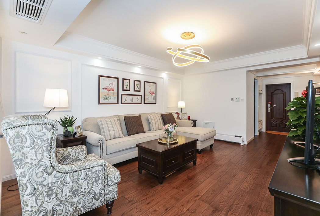 沙發(fā)后簡(jiǎn)約的線條搭配布藝沙發(fā)顯得簡(jiǎn)約而不復(fù)雜，條線采用對(duì)稱的手法，布藝沙發(fā)搭配實(shí)木茶幾，2側(cè)的茶幾，都在凸顯出現(xiàn)代美式的格調(diào)。
