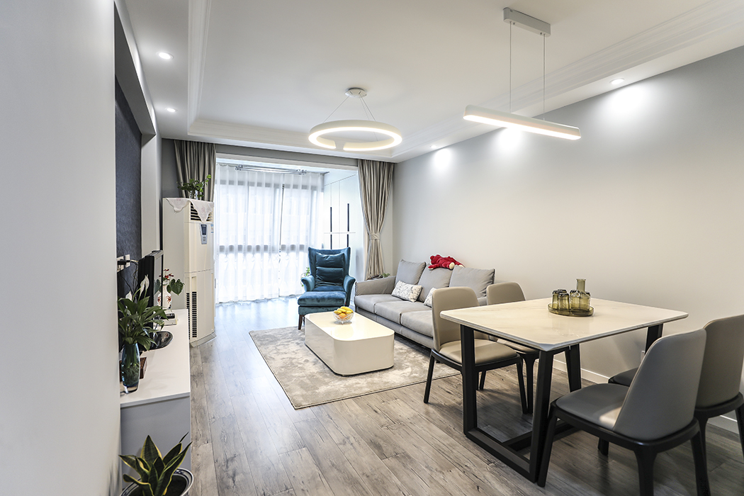 客廳整體風格以宜家北歐風格為主，整體色調以灰白為主，深灰淺灰增加對比度。簡潔的線條，灰色的墻面和強化復合地板，家中最為突出的也是一把沙發單椅，一下子讓整個空間增加立體感。
