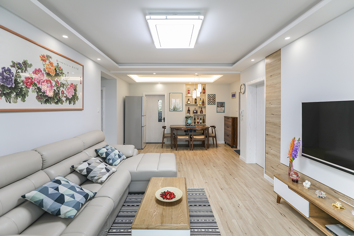 客廳區(qū)，電視背景連接地面整體采用同款地板，視覺(jué)上得到延伸，整體則由淺灰色構(gòu)簡(jiǎn)潔背景，并添入不少具生活質(zhì)感的軟裝，交織出兼具美觀，舒適的質(zhì)感視野。
