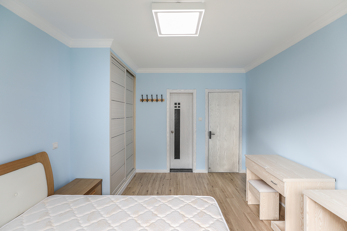 主臥，選用了淺藍(lán)色做為主墻色彩，業(yè)主每年定期出國(guó)旅游，說(shuō)想把海的顏色留到家里，搭配木紋色家具，勾勒不受干擾的睡眠情境！
