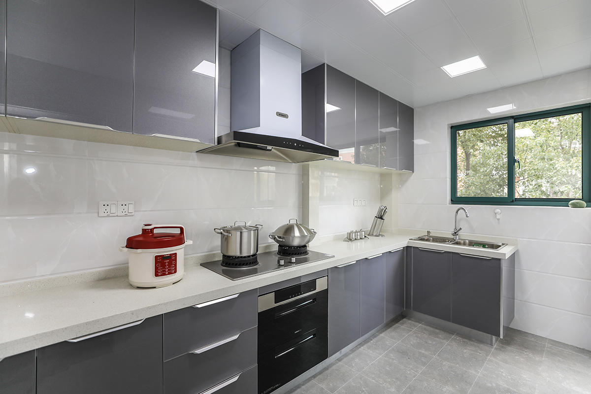 廚房區(qū)，因?yàn)闃I(yè)主喜好做美食，使用頻率較高，所以選了亮晶灰色門板，容易擦洗打理，素色墻磚，讓空間變得更加純粹
