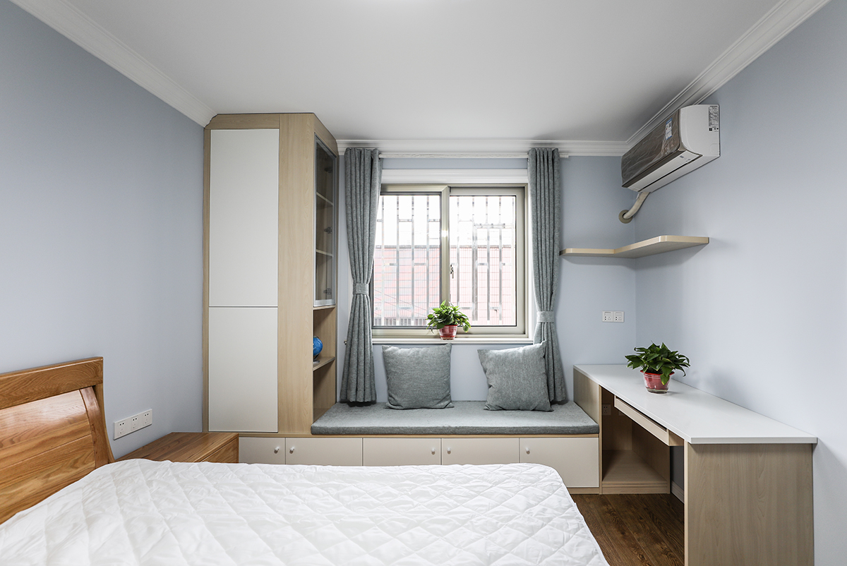 主臥室采用原木色的窗體加以咖色的窗簾使得本身單調(diào)的色彩空間立馬體現(xiàn)出色彩的多樣話和柔和度，使得整體色彩非常的舒服，給人以非常舒服的休息環(huán)境，白的的家具使得色彩反差非常的大，立體效果非常的舒服，體現(xiàn)業(yè)主的追求極簡自由的生活。
