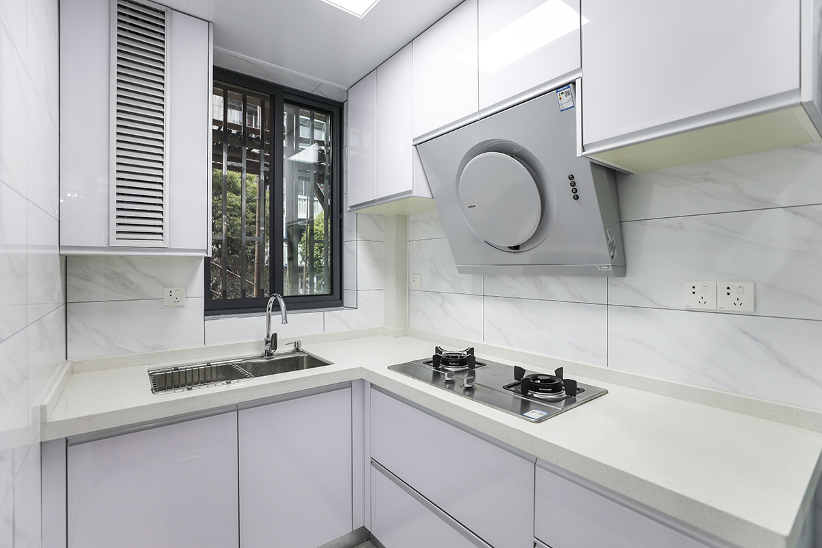 廚房是使用頻率最高的區(qū)域，不但要功能齊全，又要方便清潔好打理，所以色調(diào)上采用白色金鋼門板、白色大理石紋理墻磚配上米黃色石英石臺面。空間簡潔、干凈，方便清理，色調(diào)上又不單一。
