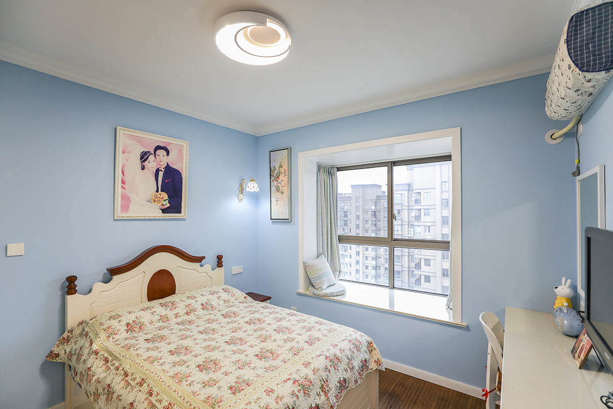 主臥墻面仍然是女主人最?lèi)?ài)的藍(lán)色，配上地中海風(fēng)格的木床和碎花床藝，加上深色地板，整個(gè)空間靜謐而美好。
