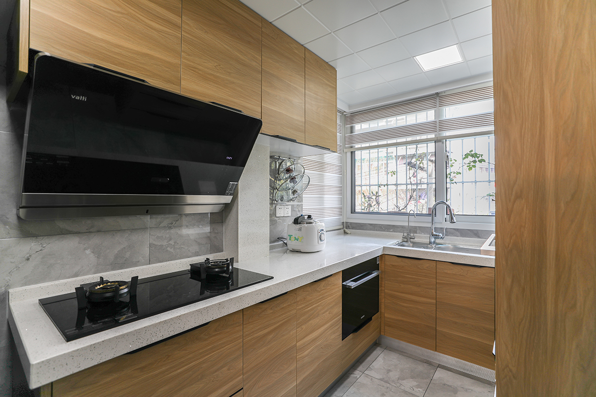     U型的廚房間，木飾面的柜門(mén)，金色的冰箱，灰色的墻地磚，讓廚房更加富有實(shí)用性、功能性，美學(xué)與使用的結(jié)合。更加讓空間具有輕奢的感覺(jué)。
